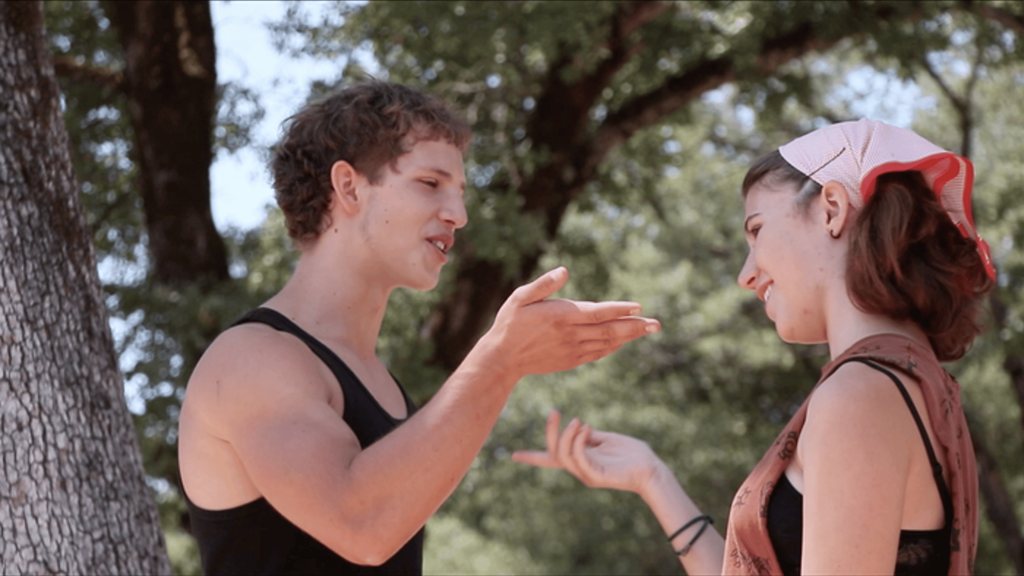 Two actors mid-scene outdoors, caught in dappled light.